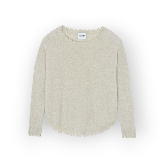 Ygreque Kujten Mela oatmeal cashmere sweater with a round neck and asymmetrical hemline on a plain background
