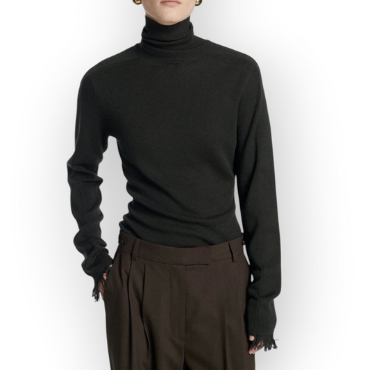 Model wearing a dark brown Frenken merino wool turtleneck sweater with slim fit and delicate fringe cuff details.