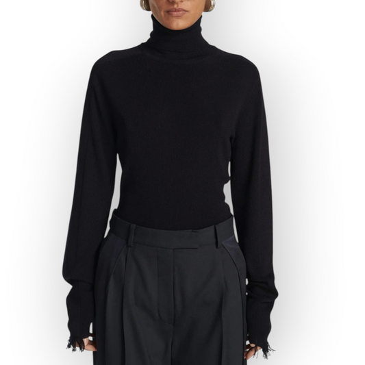 Ygreque Frenken navy merino wool slim turtleneck sweater with long sleeves and delicate fringe cuffs on a model