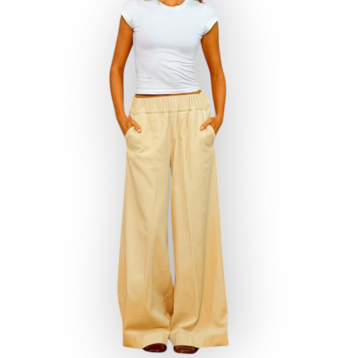 Model wearing Ygreque Sea Me Happy ecru organic cotton corduroy wide-leg trousers against a textured yellow wall