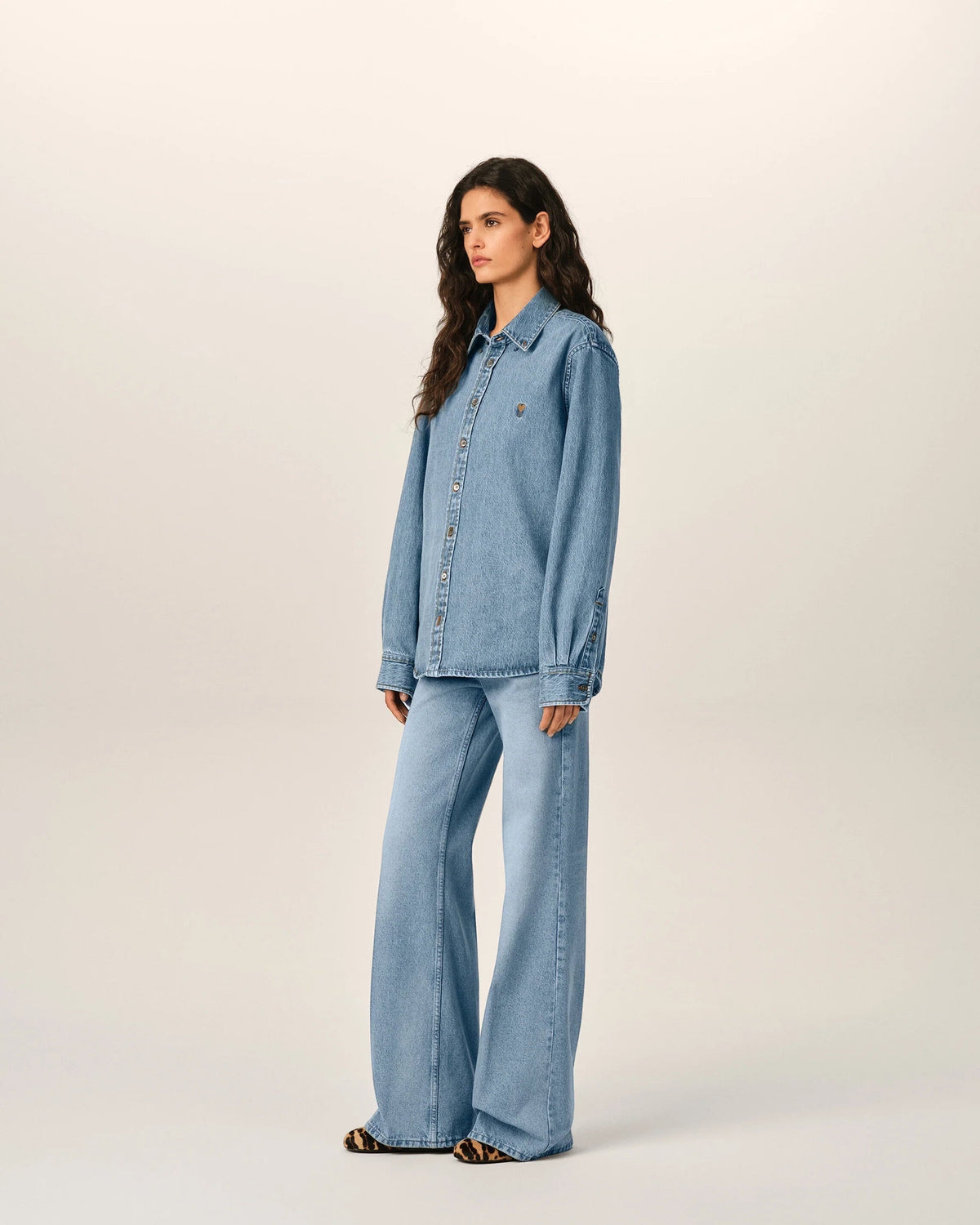 Ygreque Ami Paris unisex light blue denim shirt with tobacco stitching and Ami de Coeur embroidery on a model
