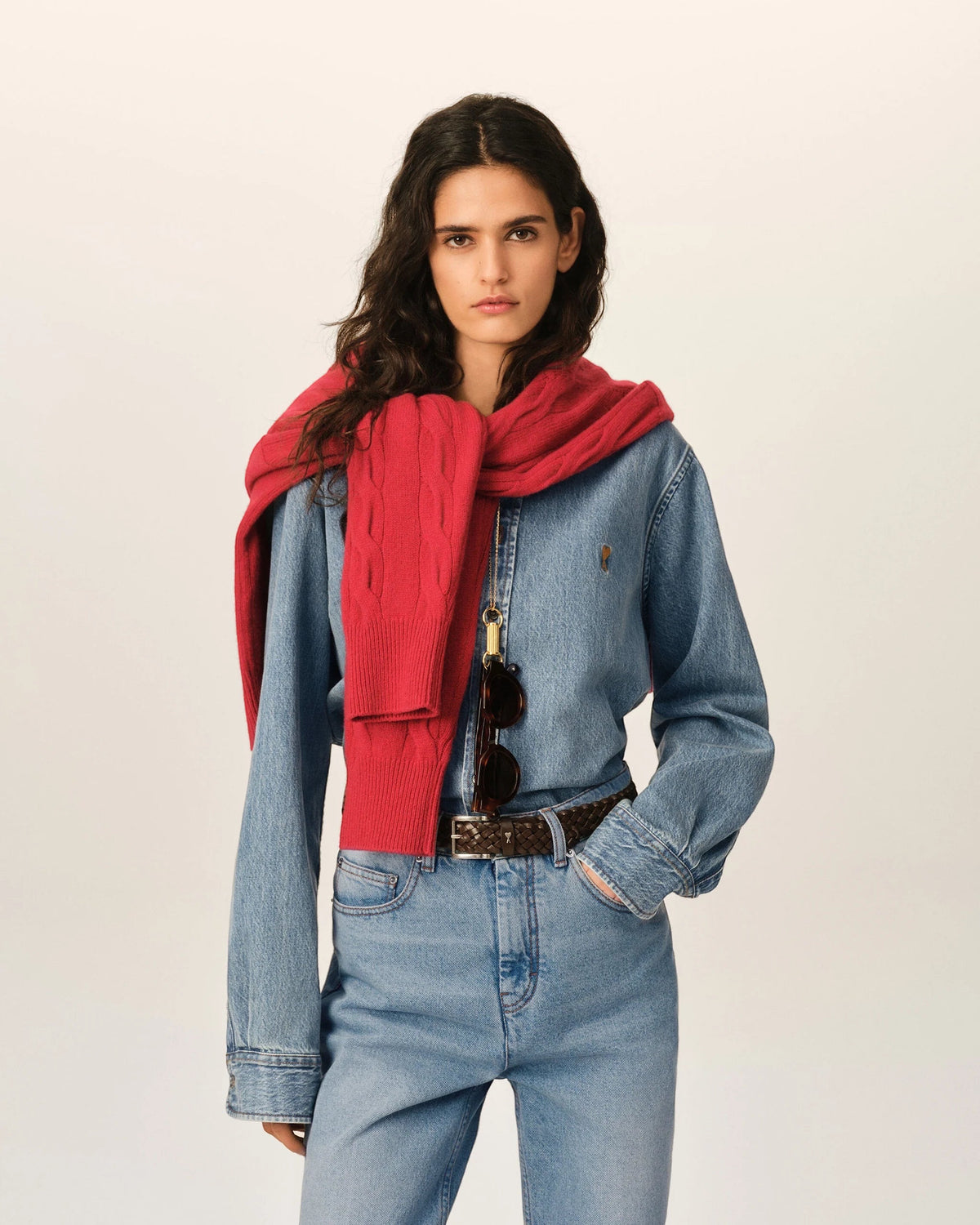 Ygreque Ami Paris light blue denim shirt with tobacco embroidery on a model wearing a red sweater over shoulders